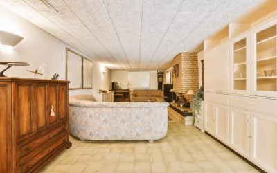 a living room with white walls and wood furniture in the center of the room is an open kitchen, dining area