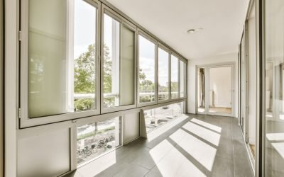 an empty room with large windows and floor to ceiling glass doors that look out onto the cityscapea