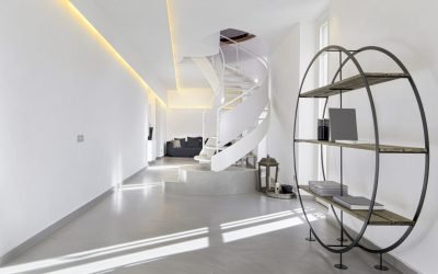 interiors of a modern living room in the apartment in the foreground  a bookcase in the center of room the spiral staircase and in the background the sofa, the floor is in concrete