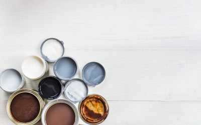 Open Cans of Different Paints, Varnish and Stain on White Wooden Background