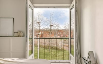 Panoramic view of old brick buildings with parking and trees from small balcony