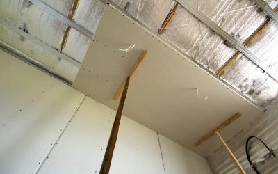 Angle view of unfinished room under construction and renovation with silver aluminum insulation foil on walls and ceiling and drywall connected to plank frame. Reconstruction and renovation concept.